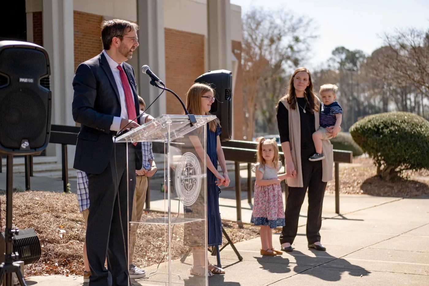 Shane Gottwals addressing residents at a Houston County podium with his family